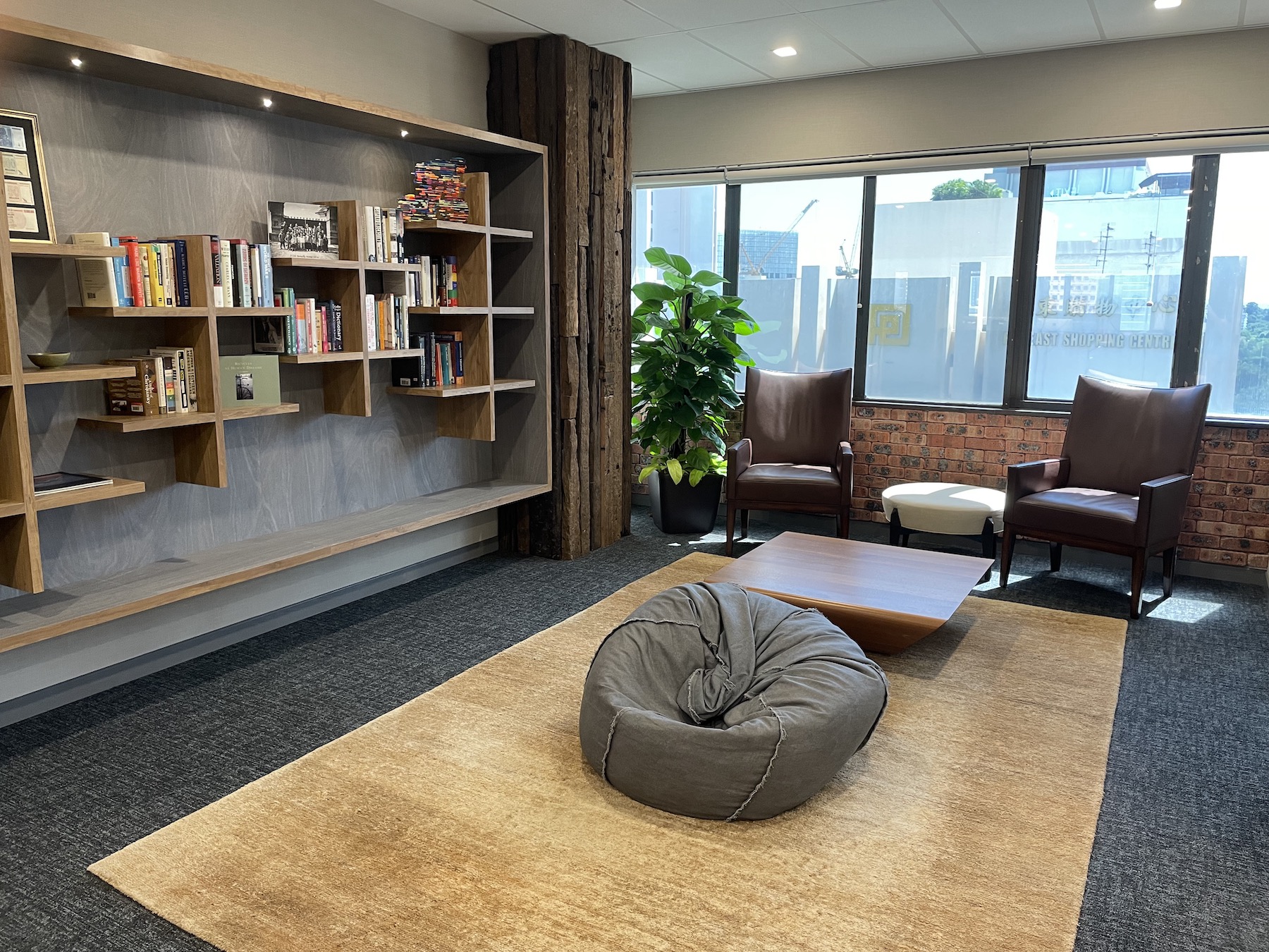Lonsdale Capital office lounge area with leather chairs, bookshelves and large windows